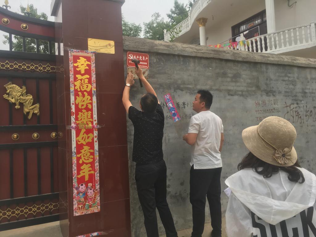 区委书记为军人家属装订光荣牌